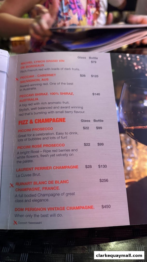 A menu featuring a selection of red wines and champagne with prices.