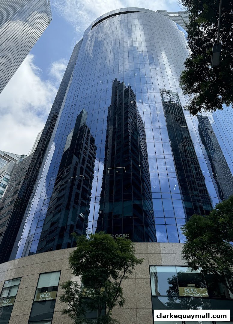 A modern glass-fronted office building reflecting the sky and surrounding architecture.