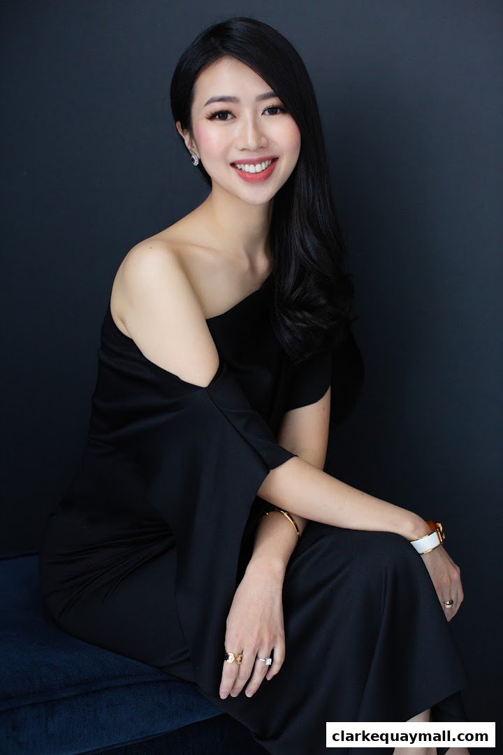 A professional portrait of a smiling woman in a black off-the-shoulder dress.