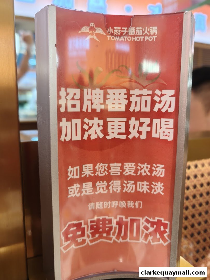 A sign for XiaoYanZi Tomato Hot Pot offering free soup thickening.