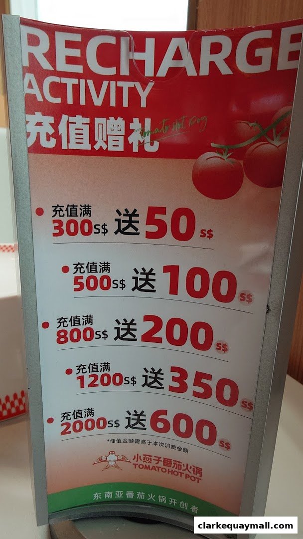 A promotional sign for XiaoYanZi Tomato Hot Pot's recharge activity with tiered bonus offers.