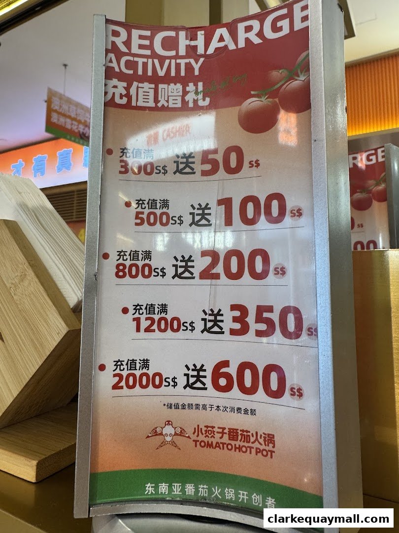 A sign advertising a recharge activity with bonus credits for Tomato Hot Pot.