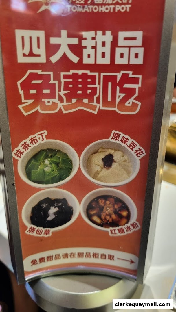 A sign advertising four free desserts at Tomato Hot Pot, featuring matcha pudding, original tofu pudding, grass jelly, and brown sugar jelly.