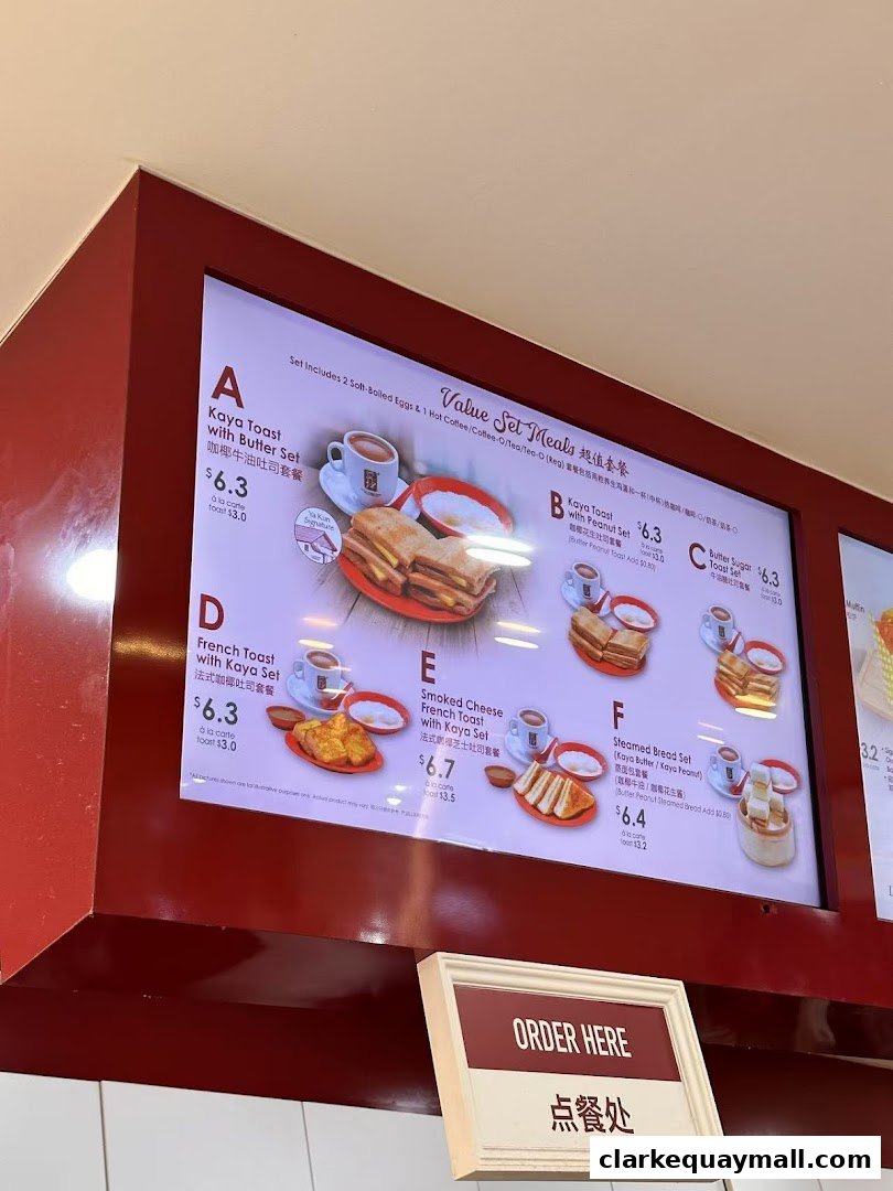 A digital menu board displaying various set meals and their prices at Ya Kun Kaya Toast.