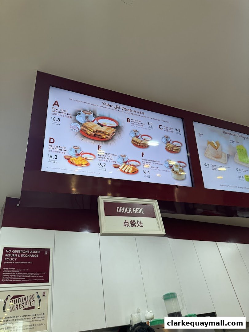 A menu board displaying various set meals and pastries at Ya Kun Kaya Toast.