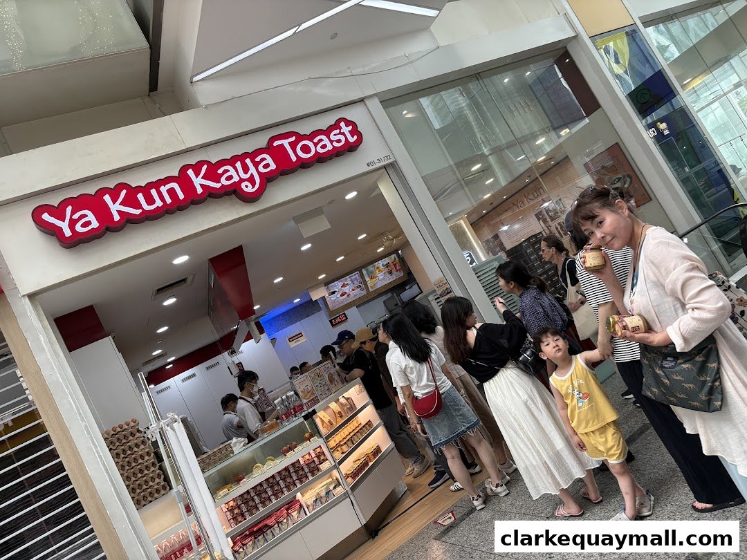 A line of people waiting outside Ya Kun Kaya Toast, a popular food establishment.