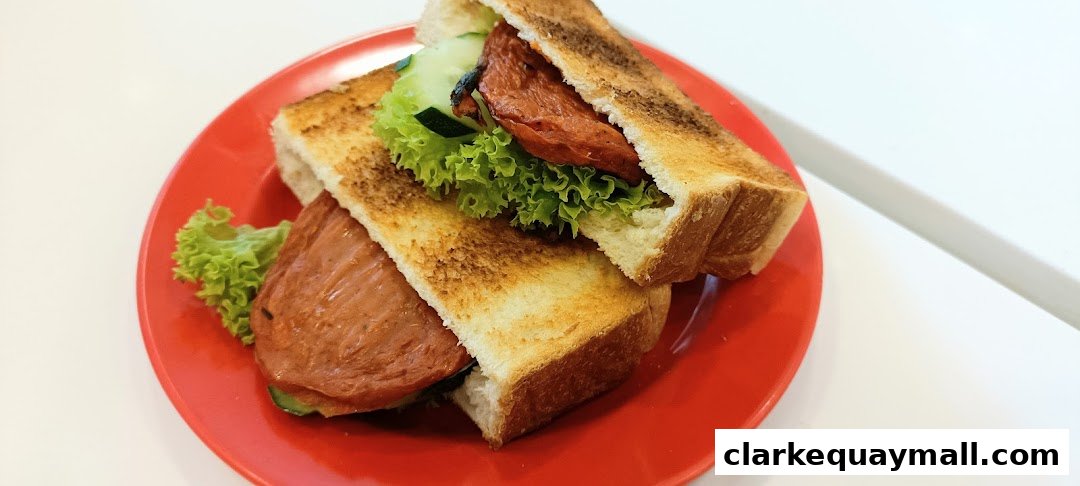 A close-up shot of a Ya Kun Kaya Toast sandwich with thick slices of meat, lettuce, and cucumber on toasted bread.