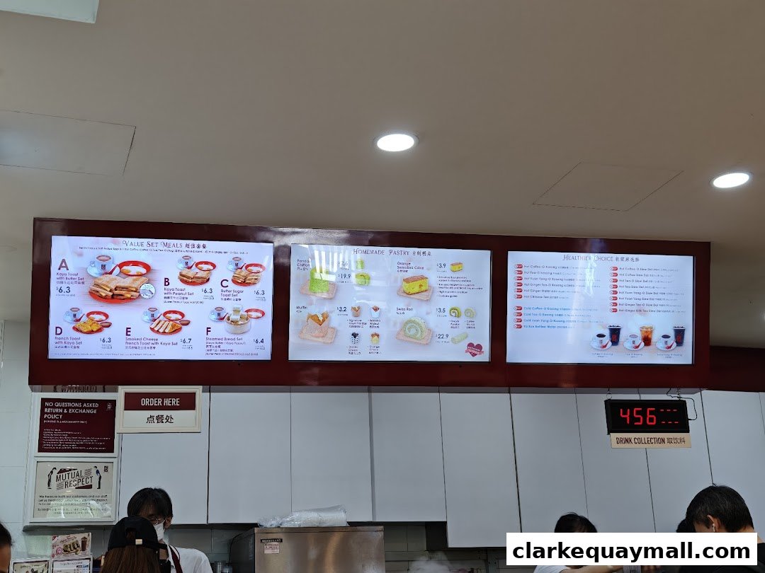 A digital menu board displaying value set meals, homemade pastries, and healthier drink choices.