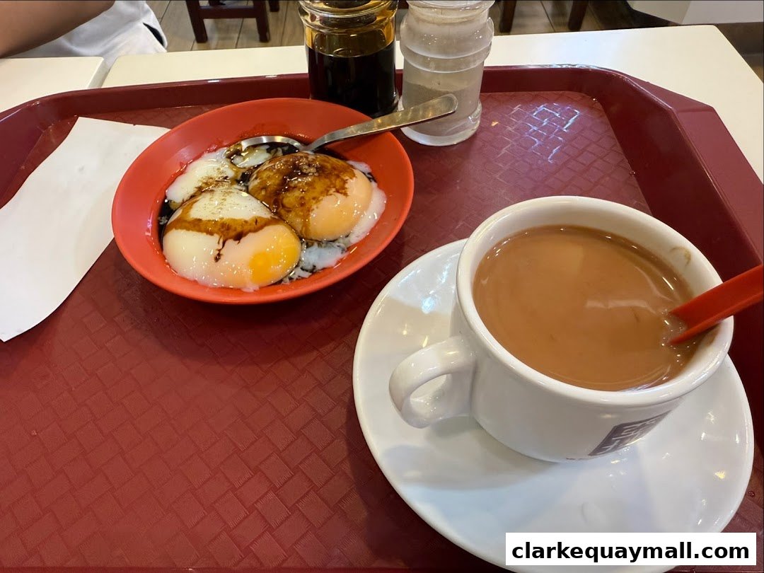 A tray with soft-boiled eggs, soy sauce, and a cup of coffee at Ya Kun Kaya Toast.