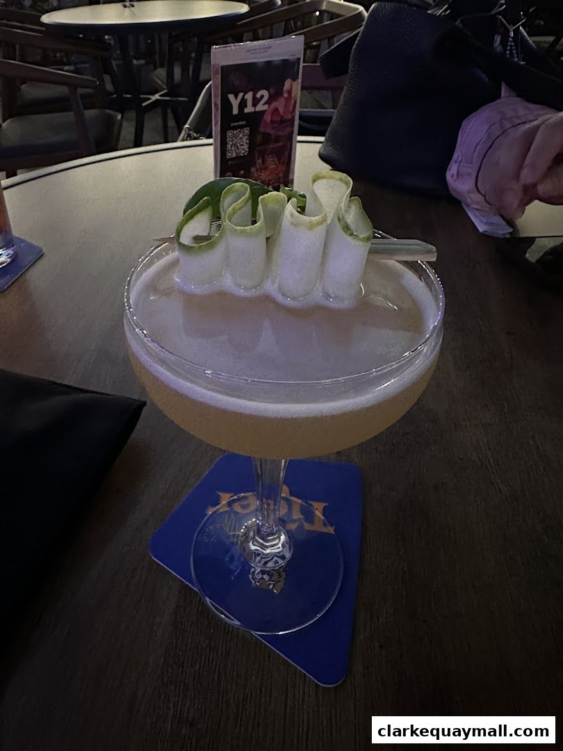 A beautifully garnished cocktail sits on a table at Yin Bar Singapore, with a menu in the background.