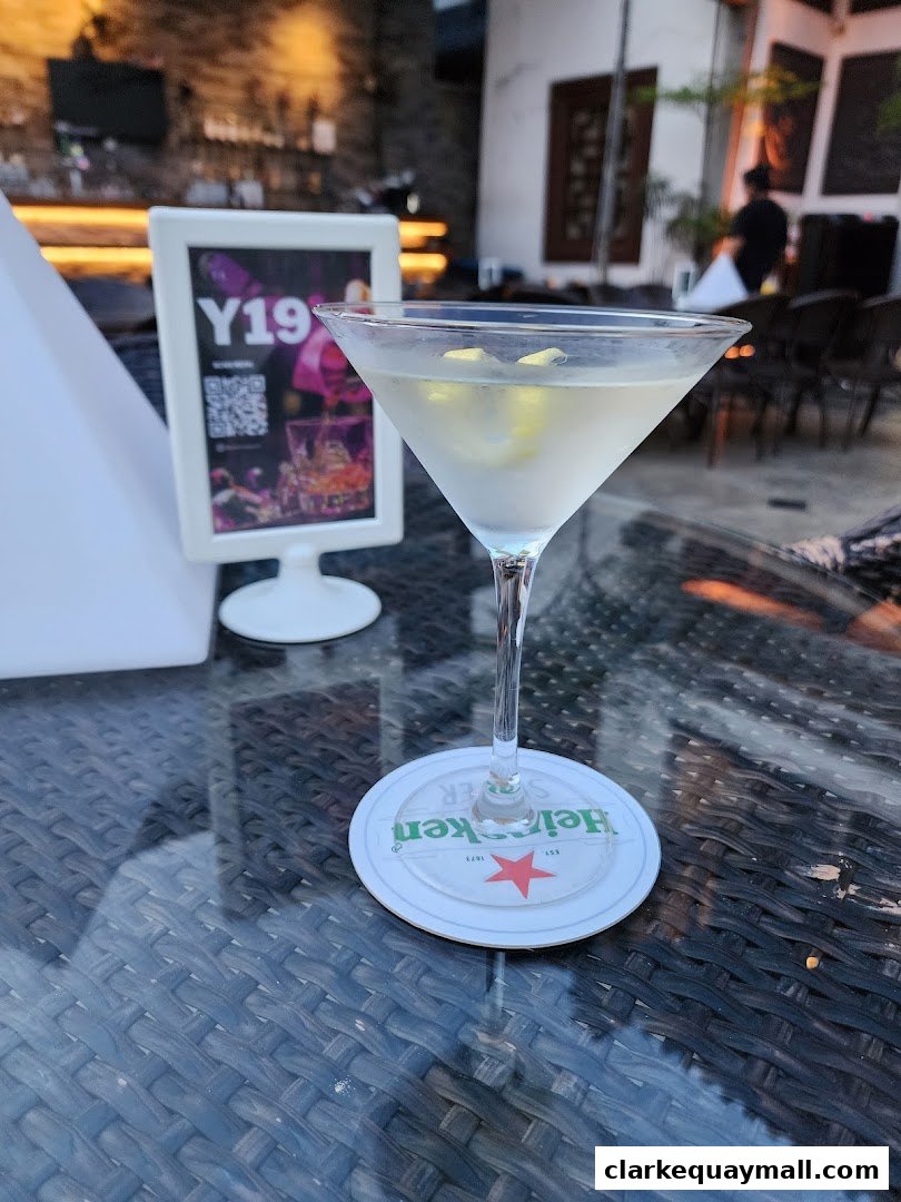 A close-up of a martini with a Heineken coaster on a table at Yin Bar Singapore.