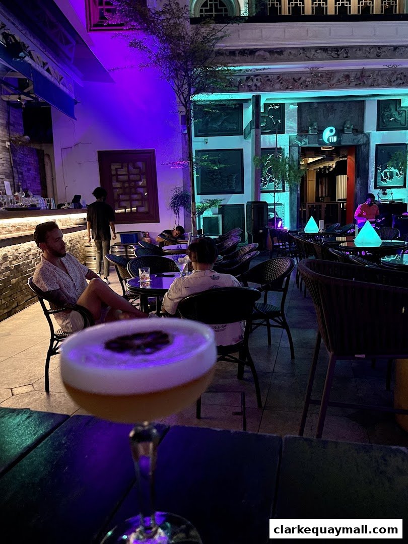 A stylish bar with people enjoying drinks and a live musician playing.