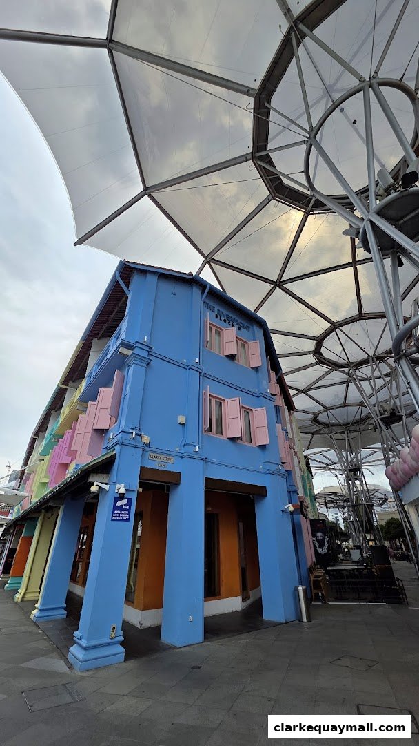 A vibrant blue building with pink shutters, part of a row of colorful shophouses.
