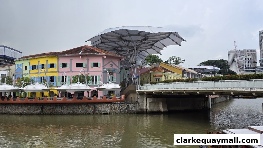 Colorful buildings line a river with a bridge and modern architecture in the background.