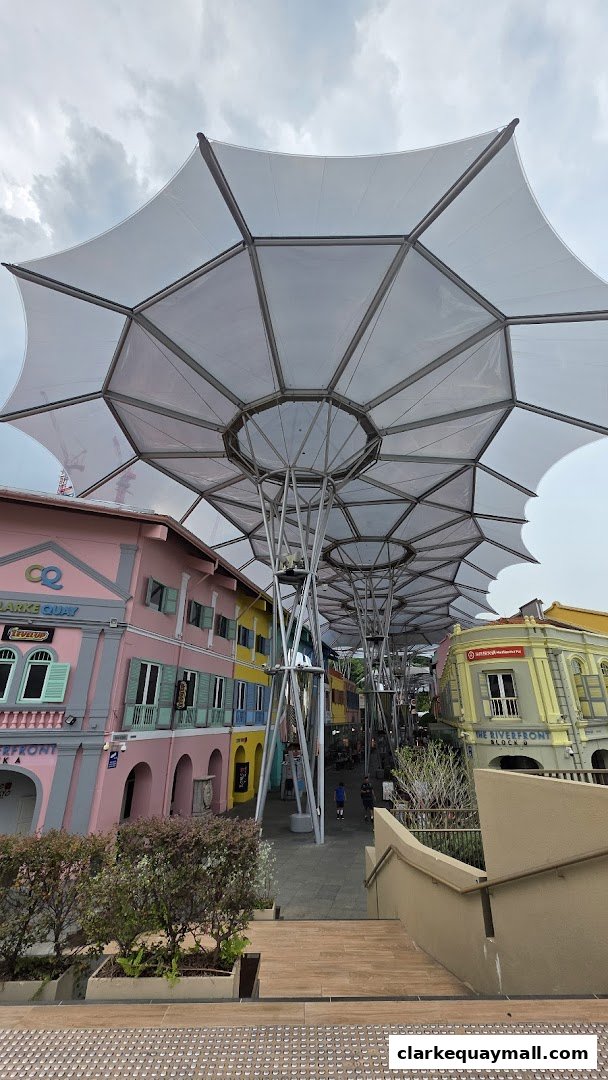 A covered walkway with colorful buildings and people walking along a scenic path.