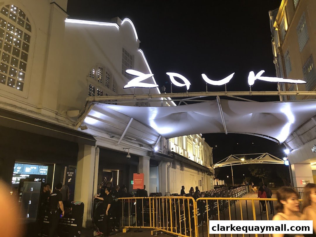 The illuminated Zouk Singapore sign above the entrance at night, with a queue barrier.