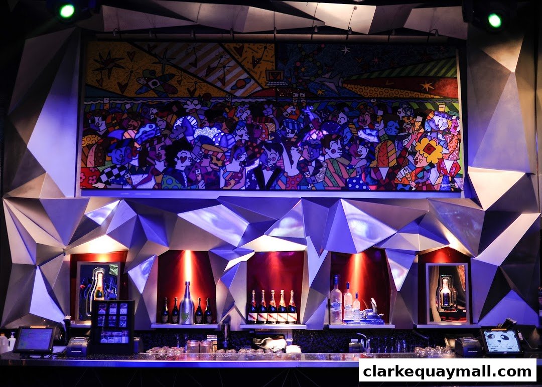 A vibrant bar area with a colorful art piece and bottles displayed on shelves.