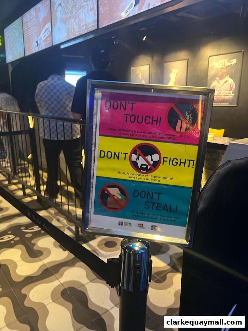 A sign with 'Don't Touch', 'Don't Fight', and 'Don't Steal' warnings is displayed in front of a queue.