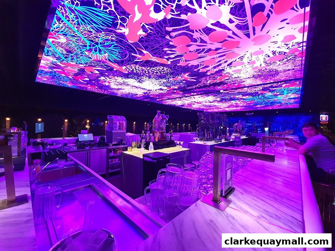 Interior of a bar with a vibrant, illuminated ceiling and a marble bar counter.